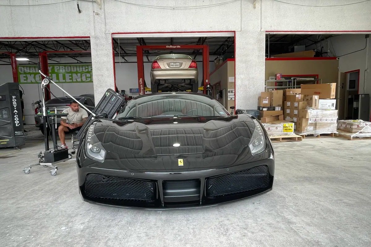 Black Ferrari undergoing final reflection inspection