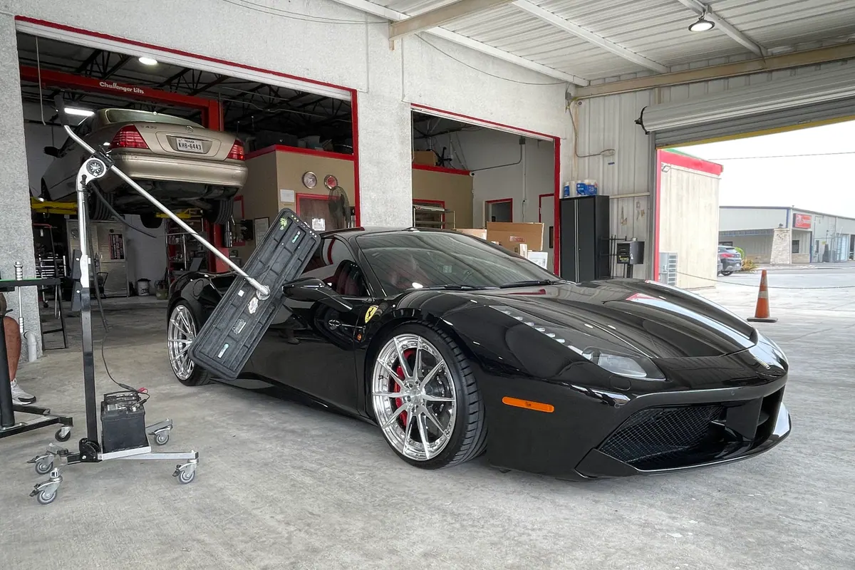 Ferrari beside a paintless dent repair inspection light