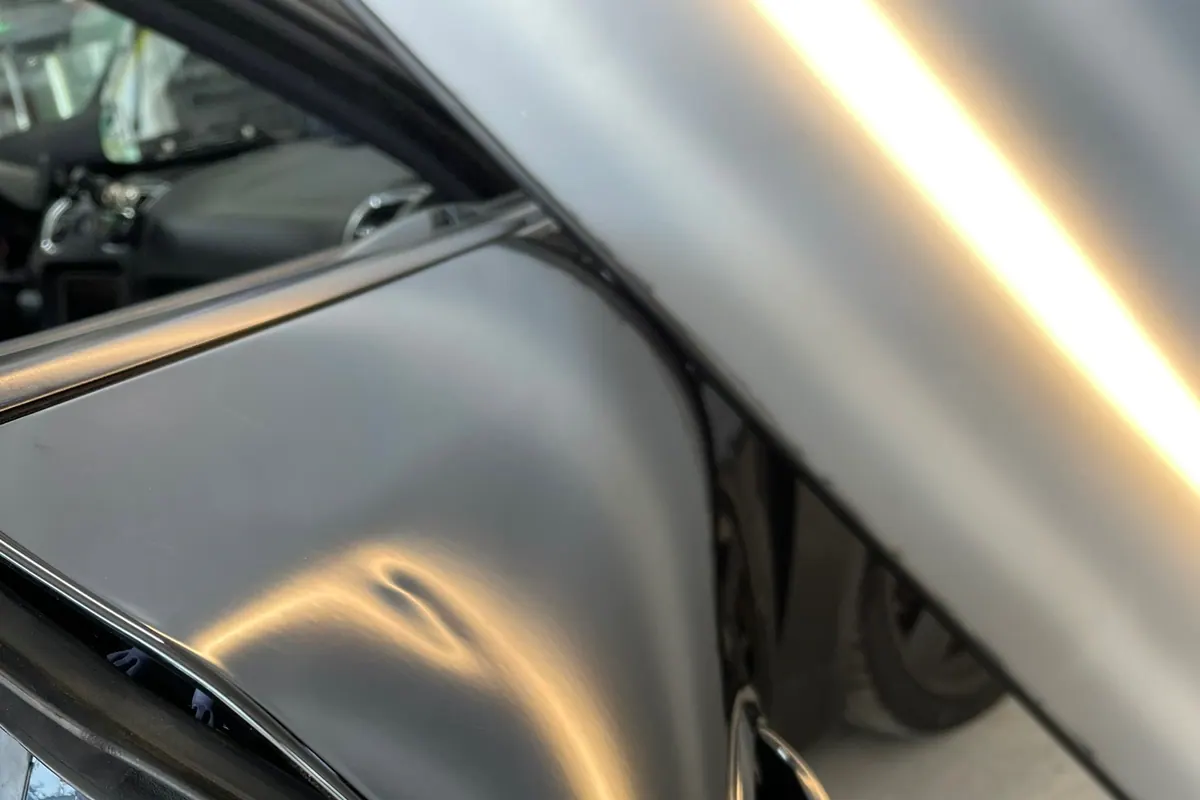 Porsche dent diagnosed beneath a reflection light