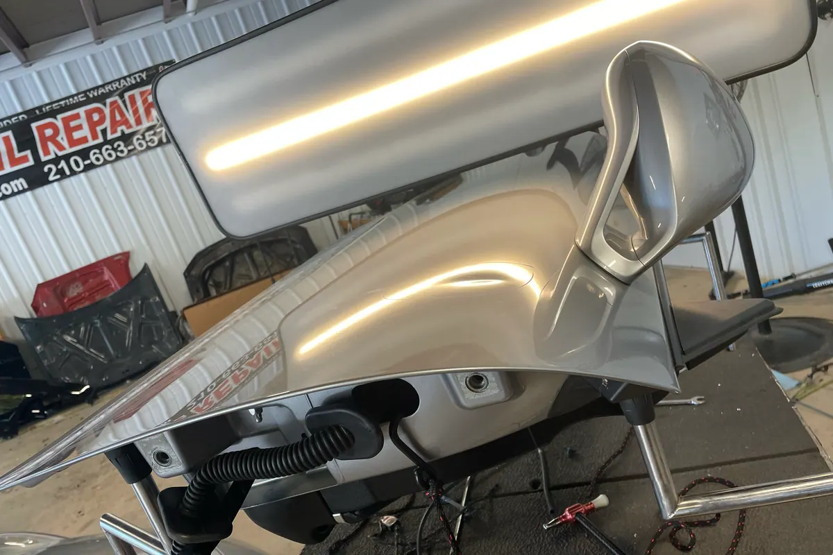 Silver Porsche fender under a dent reflection board